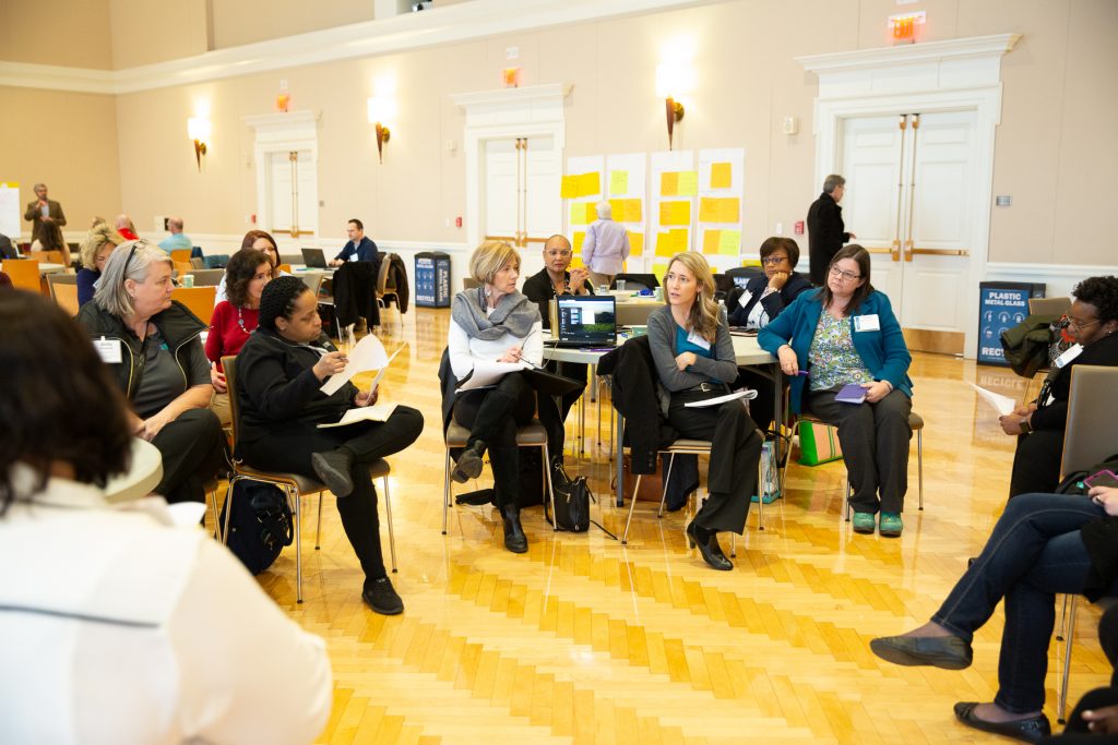 multiple participants seating within the main ballroom and participating in conversation